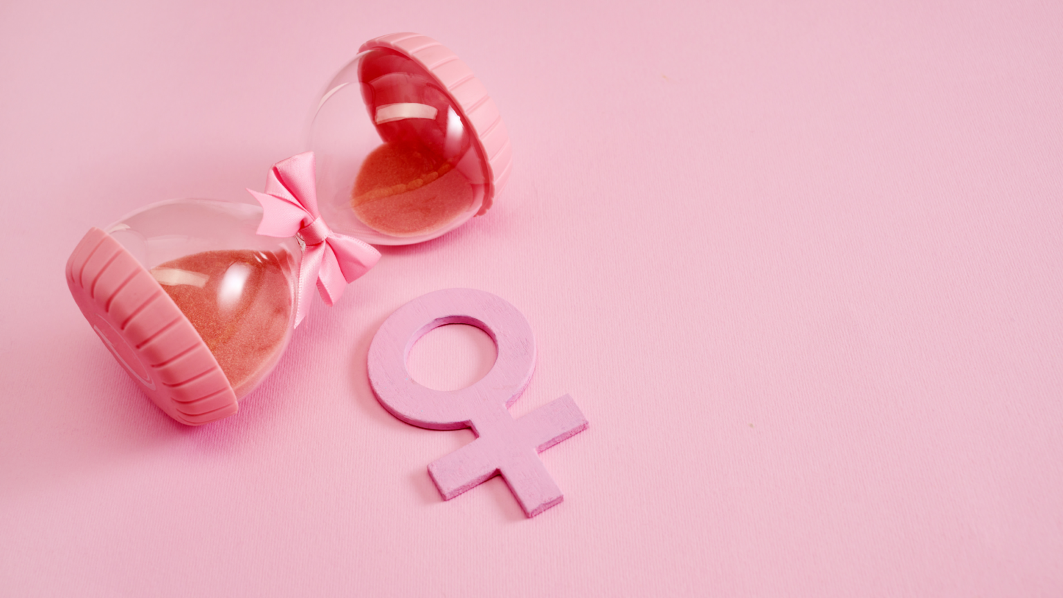 Pink hourglass next to female symbol representing perimenopause and hormonal changes