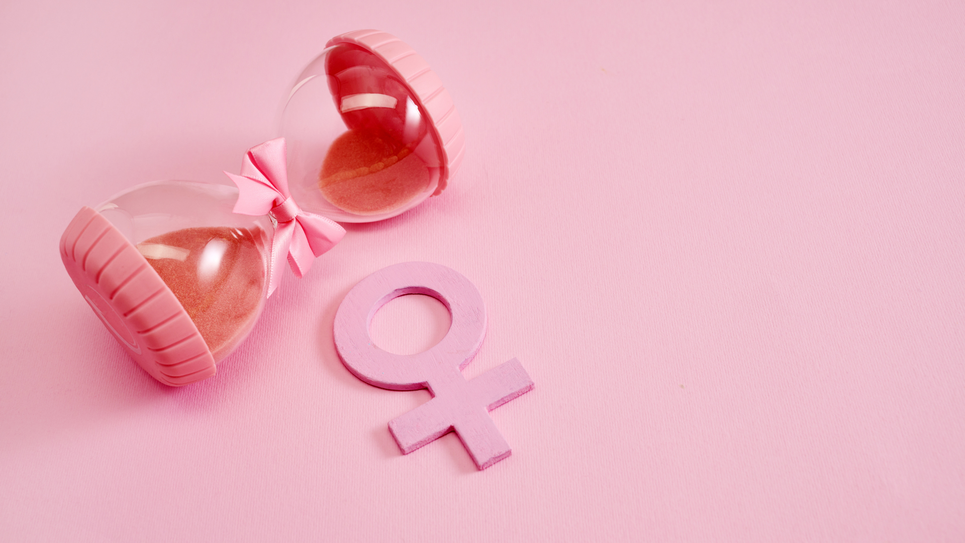 Pink hourglass next to female symbol representing perimenopause and hormonal changes