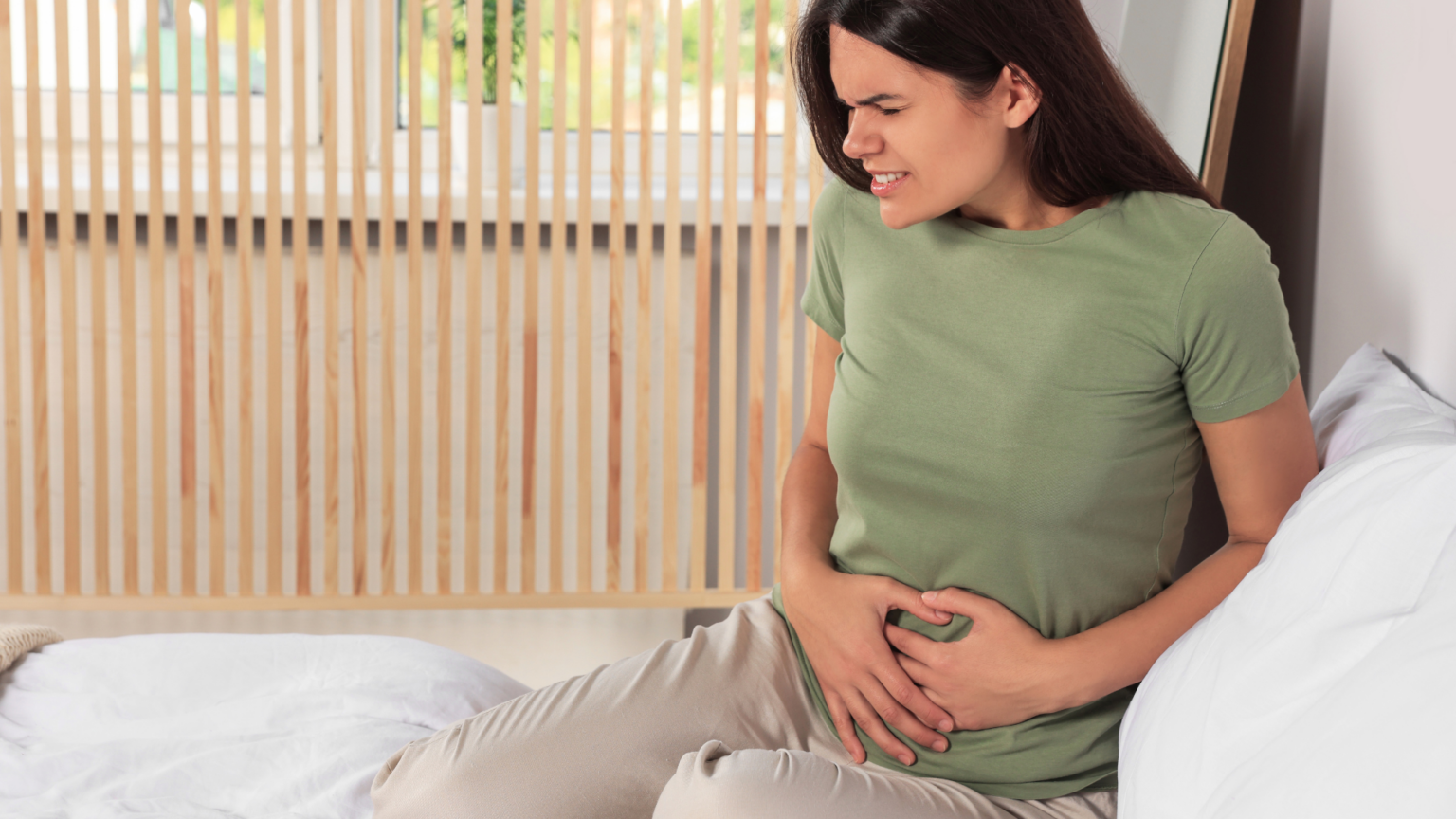 Woman holding lower abdomen in pain